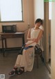 A woman sitting on a chair in front of a microwave.