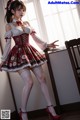 A woman in a red and white dress and stockings posing for a picture.