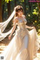 A woman in a wedding dress is walking in the woods.