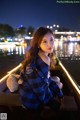 A woman sitting in a boat with a teddy bear.