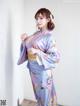 A woman in a blue kimono posing for a picture.