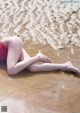 A woman in a red bathing suit laying on the beach.